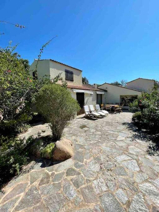 une maison dotée d'une terrasse en pierre avec des chaises et des buissons dans l'établissement Piana, à Porto-Vecchio