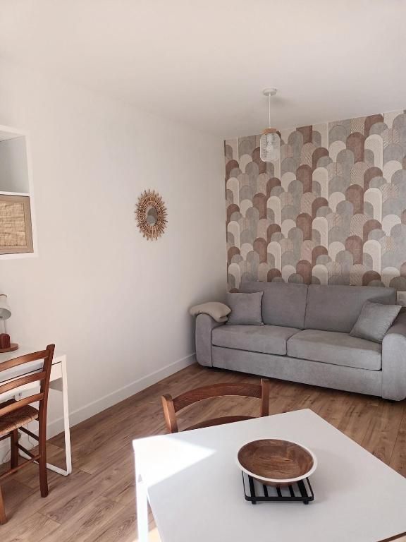 un salon avec un canapé et une table dans l'établissement Studio 4 Calme et Moderne Proche des Thermes, à Rochefort