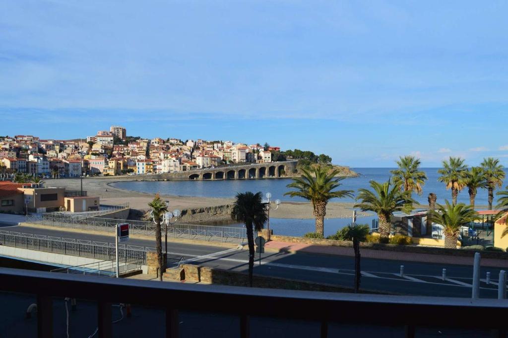 - une vue sur une plage bordée de palmiers et un pont dans l'établissement Appartement 3 pièces BANYULS SUR MER BN020-028, à Banyuls-sur-Mer