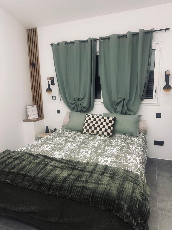 - une chambre avec un lit et des rideaux verts dans l'établissement Chambre confort, à Merpins