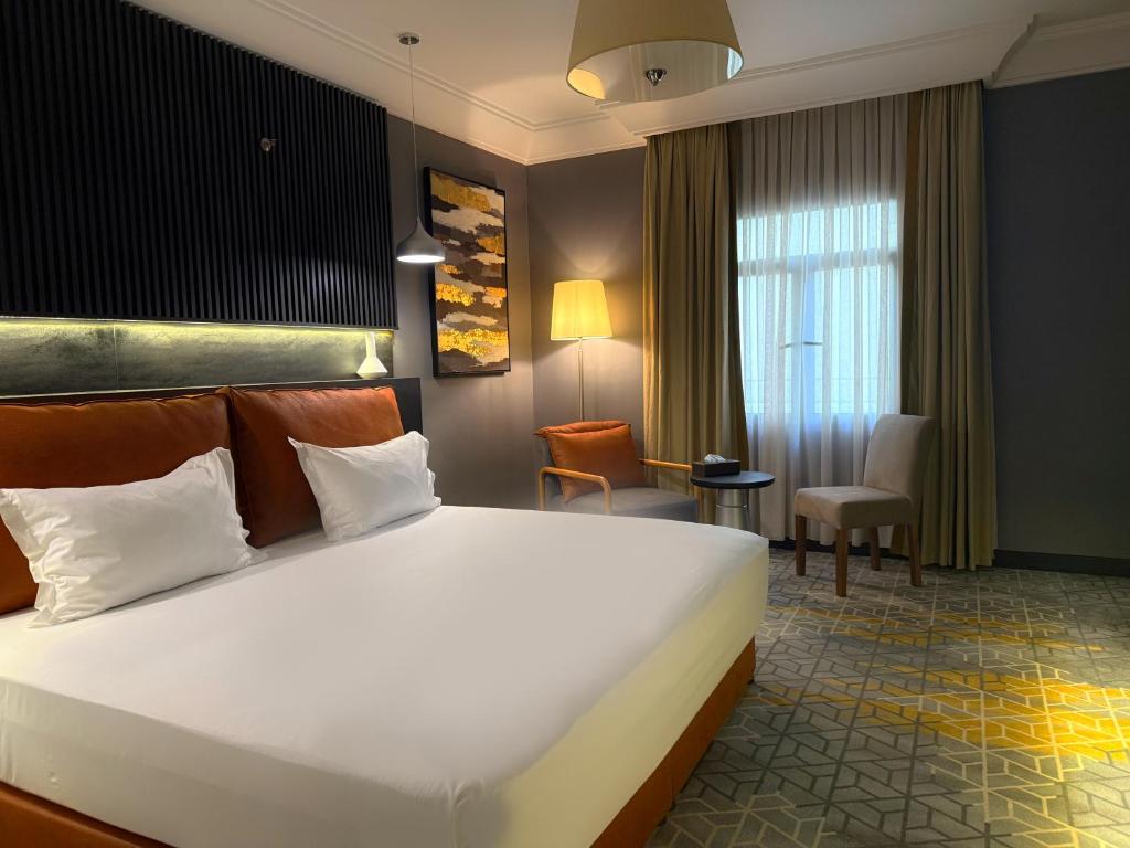 une chambre d'hôtel avec un grand lit et un bureau dans l'établissement Crown Town Hotel, à Djeddah