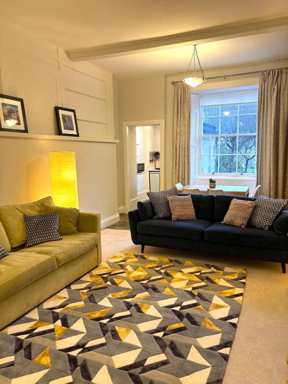 a living room with two couches and a rug at Spacious Apartment in Central Edinburgh in Edinburgh