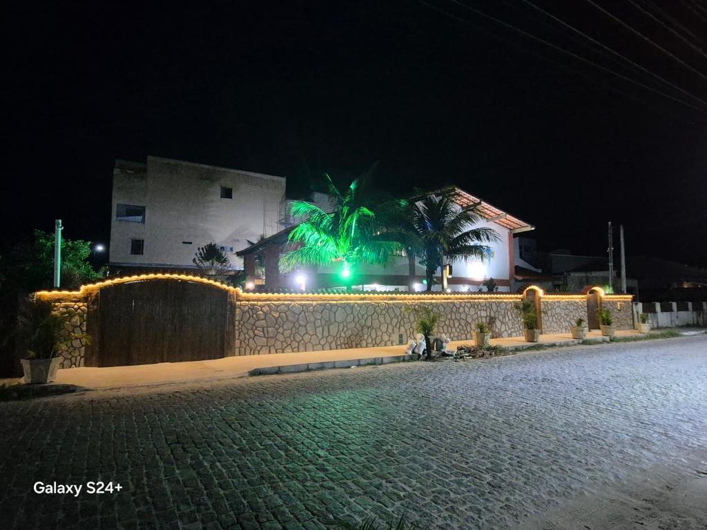 a building with green lights on a street at night at Pousada Casa Da Arara suíte 104 in Saquarema