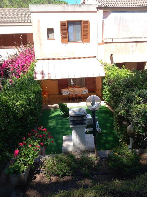 a garden with a bench and flowers in front of a building at Casa Licia Sorso in Marina di Sorso