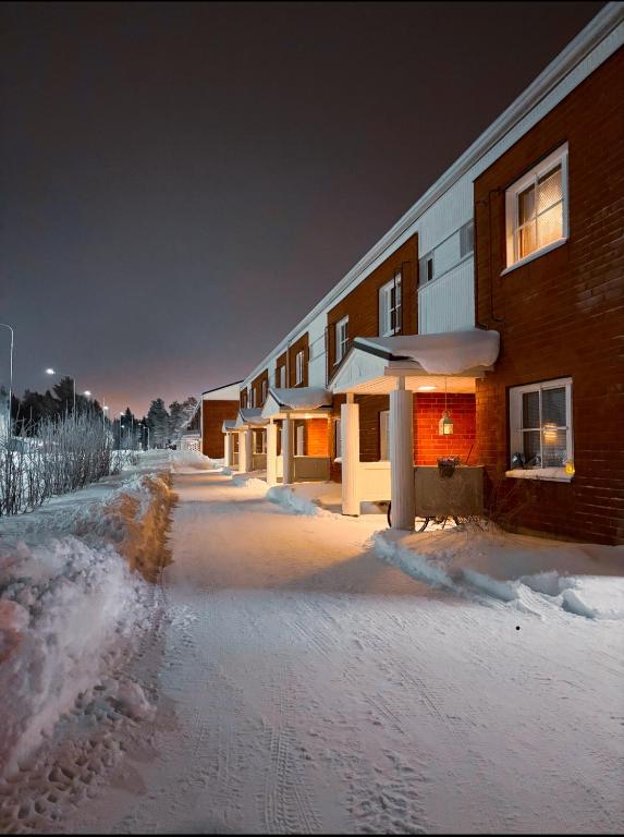 a building with snow on the ground in front of it at Lapland Second Home in Rovaniemi