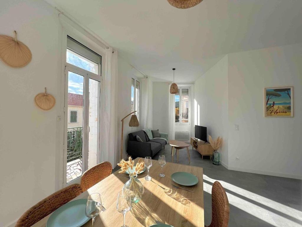 un salon avec une table et des chaises en bois dans l'établissement Appartement lumineux proche gare, à Hyères