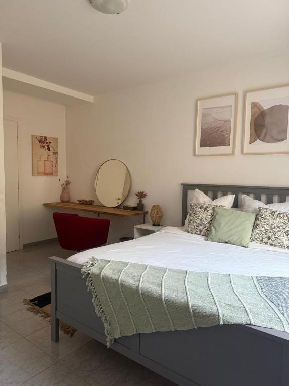 une chambre avec un grand lit et un miroir dans l'établissement Bas de Villa à 15 min de Nice avec piscine, à Carros