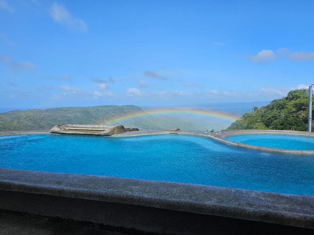 a rainbow over a pool of water with a view at Casona Cocobolo el mejor lugar de Costa Rica in Guanacaste