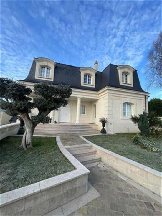une grande maison blanche avec un arbre devant dans l'établissement Maison spacieuse à Chelles, à Chelles