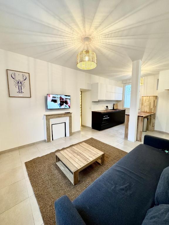 un salon avec un canapé bleu et une table basse dans l'établissement Charmant Appartement - Stationnement gratuit, à Nantes