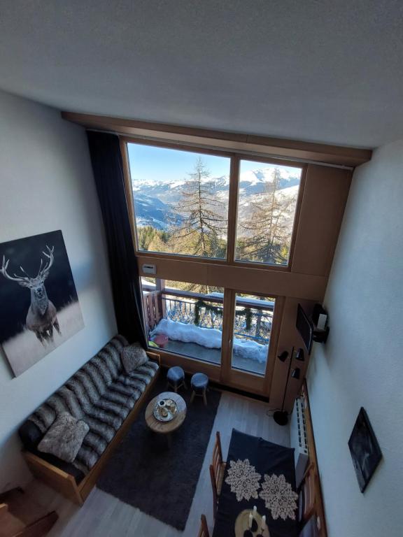 uma vista superior de uma sala de estar com uma grande janela em RESIDENCE LE RUITOR Duplex dernier étage vue panoramique classé 4 Cristaux Paradiski em Arc 1800