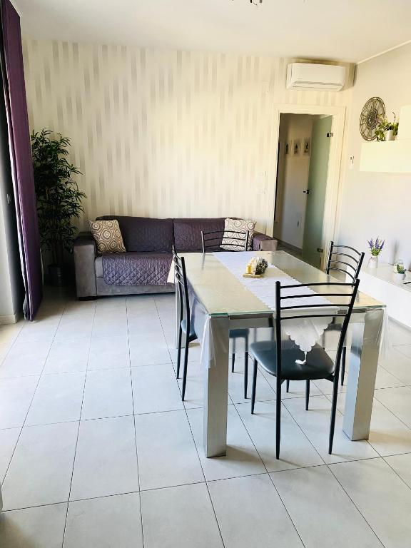 a table and chairs in a living room with a couch at Casa Mia in LʼAnnunziata
