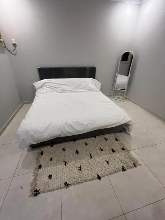 a bedroom with a bed with a rug on the floor at شقة للإيجار شهري اسبوعي يومي تبعد عن الحرم المكي 4 كيلو-قريبة من قطار الحرمين قريبة من محطة باصات رئيسية in Aţ Ţunḑubāwī