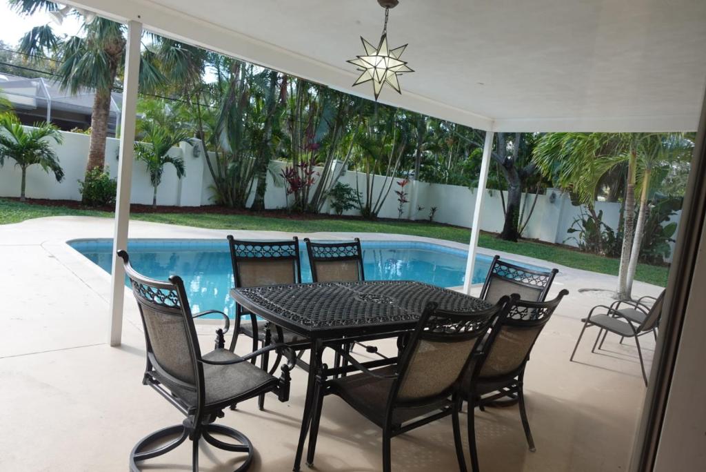 a patio with a table and chairs next to a swimming pool at H-1 746 Fiddlewood Rd Vero Beach Florida in Vero Beach