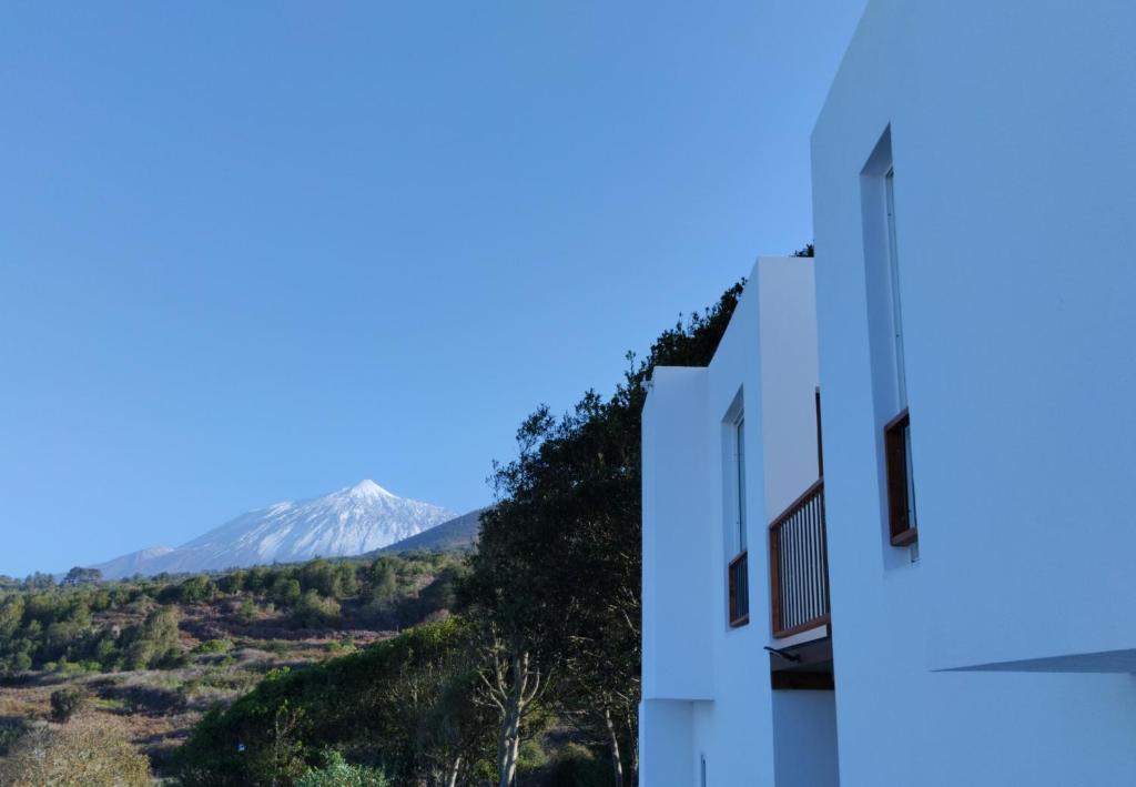 a white building with a mountain in the background at Casa Lana in San Juan del Reparo