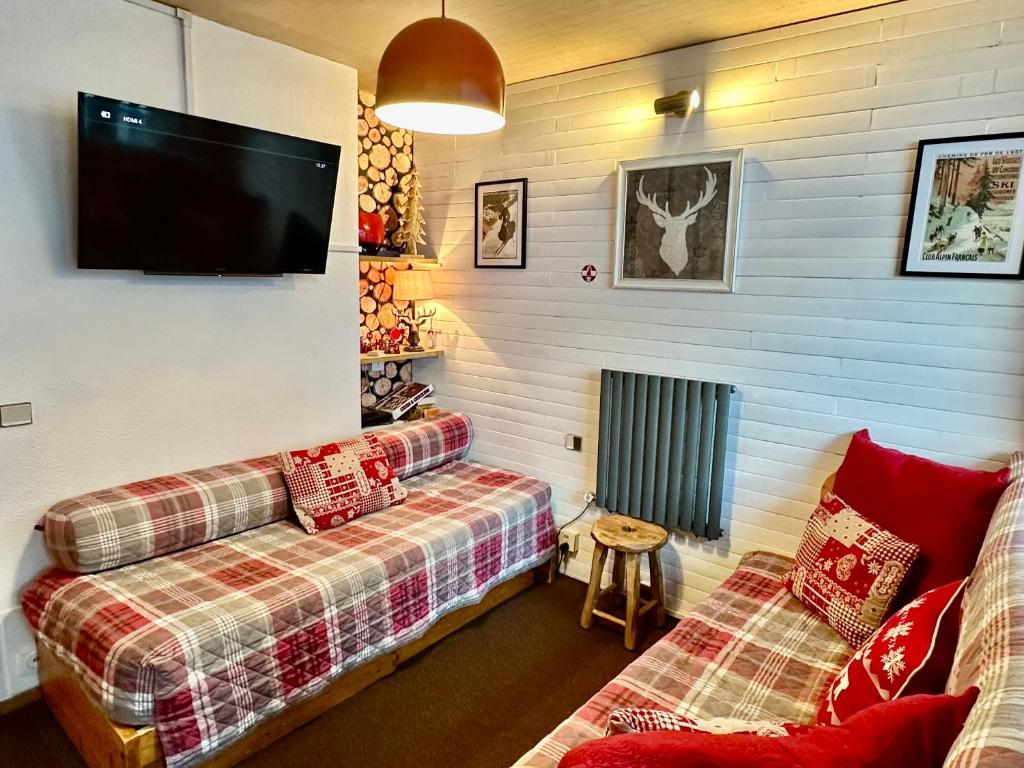 un salon avec deux canapés et une télévision à écran plat dans l'établissement Slopeside La Plagne Bellecote, à La Plagne Tarentaise