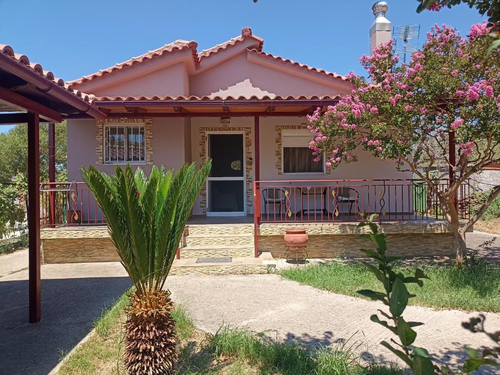 a house with a palm tree in front of it at Emis House Krioneri in Kryonéri