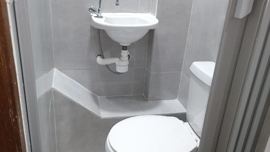 a small bathroom with a toilet and a sink at Hospedagem Cinelândia AP 617 in Rio de Janeiro