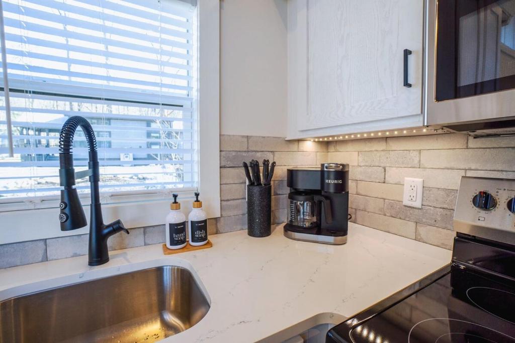 a kitchen counter with a sink and a coffee maker at Tiny home Fire Pit Fishing Pond BBQ Sage Cabin in Gatlinburg