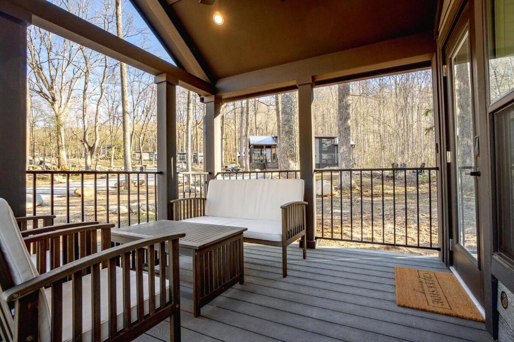 a screened porch with a bench and a table at Tiny home Fire Pit Fishing Pond BBQ Sage Cabin in Gatlinburg