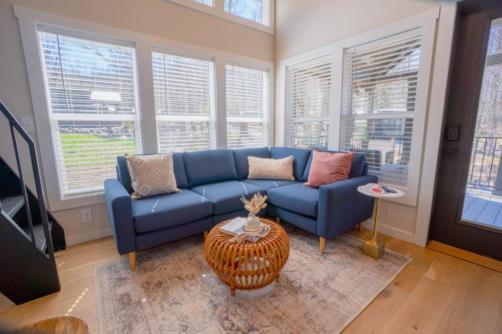 ein blaues Sofa im Wohnzimmer mit Fenstern in der Unterkunft Tiny Home Firepit BBQ Fishing Willow Cabin in Gatlinburg