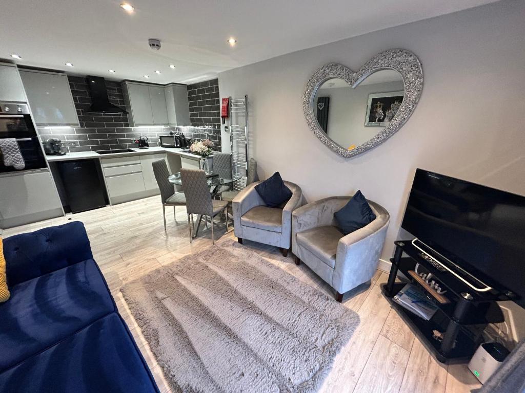 a living room with two chairs and a heart mirror at The Penthouse - Luxury 2 Bed Apartment in Skegness in Skegness