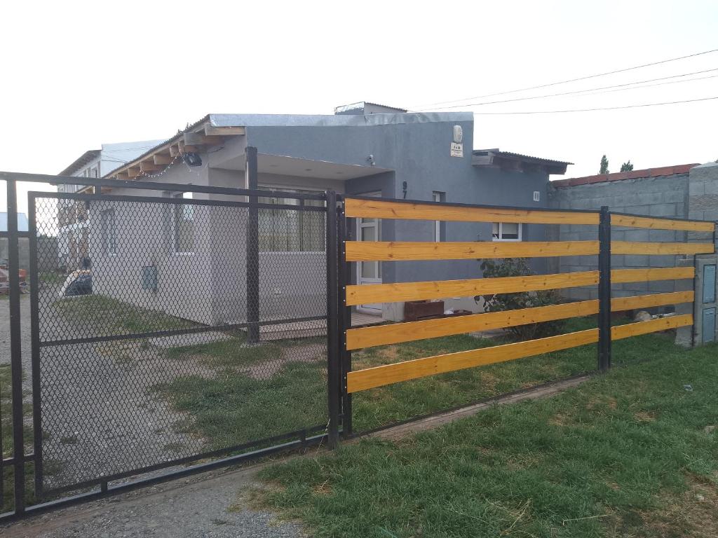 a wooden fence with a gate in front of a building at Sosiego Patagonico dpto A in Perito Moreno