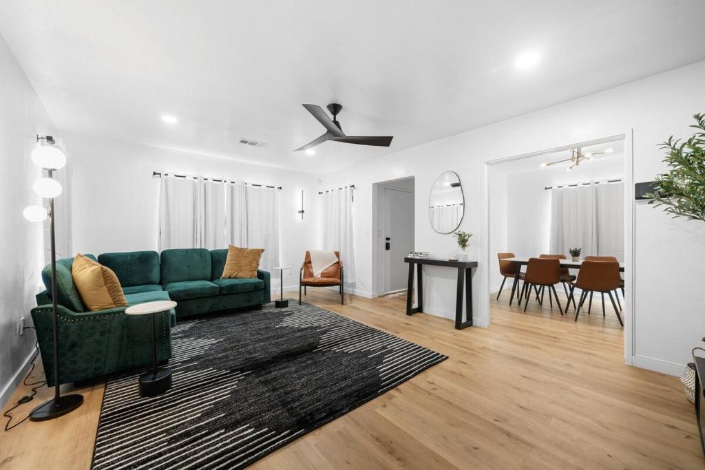 ein Wohnzimmer mit einem grünen Sofa und einem Esszimmer in der Unterkunft Bakersfield Sunset Stay in Bakersfield