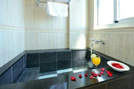 bagno con lavandino e bicchiere di succo d'arancia di 跳跳民宿 包棟首選 a Xiaoliuqiu