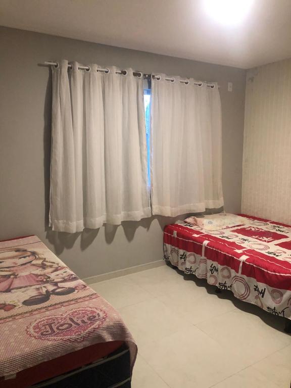 a bedroom with two beds and a window at Apartamento na Praia do Guaibim in Ponta da Areia