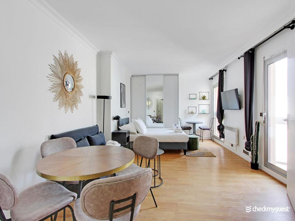 a living room with a table and a bedroom at Quiet and bright studio - 2P - Rueil Malmaison in Rueil-Malmaison