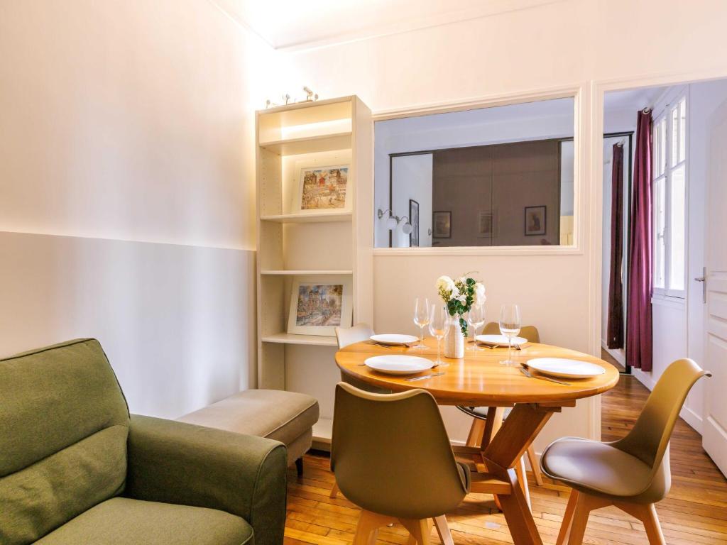 un salon avec une table, des chaises et un canapé dans l'établissement Charmant appt - 1 BDR 2P convention 15e arr, à Paris