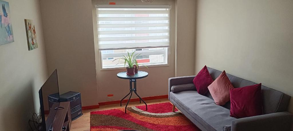 Una sala de estar con un sofá y una ventana. en Departamento Balneario Pelluco, en Puerto Montt