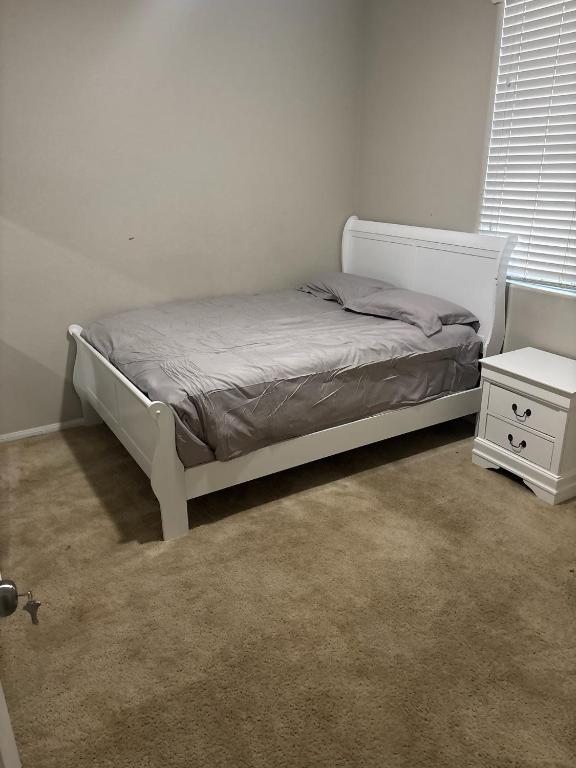 a bedroom with a bed and a night stand at Furnished room in big home in Las Vegas