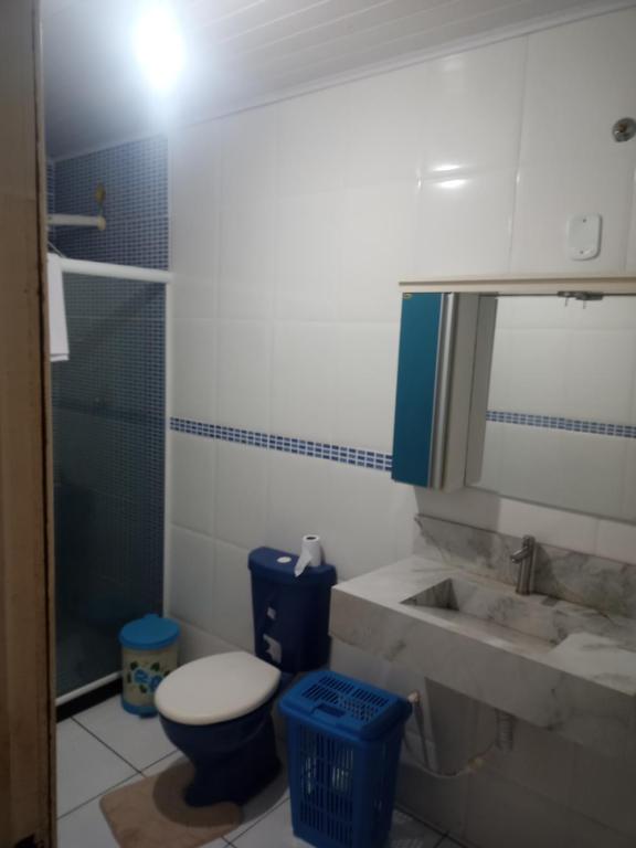 une salle de bain avec toilettes, lavabo et miroir dans l'établissement Arraial do cabo, à Arraial do Cabo
