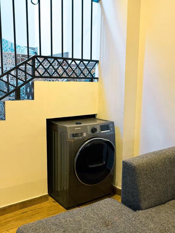 亚松森Casa moderna en Villamorra a pasos del Shopping Mariscal Lopez 2Dorm,2 garajes y Wifi的楼梯旁边的房间内的洗衣机