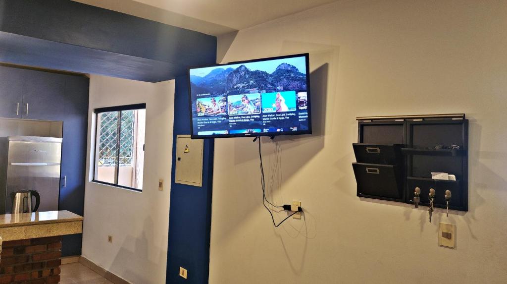 Casa moderna en Villamorra a pasos del Shopping Mariscal Lopez 2Dorm,2 garajes y Wifi的电视和/或娱乐中心