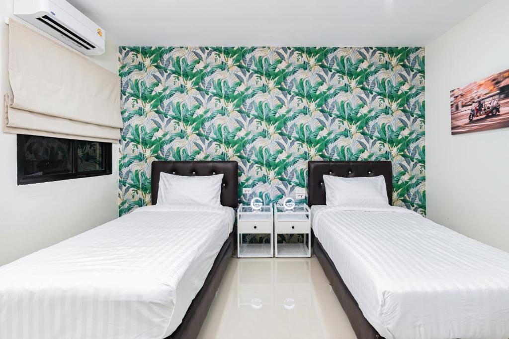 two beds in a room with a green wallpaper at Songbird Suites - Deluxe Twin Suite and Scooter in Ao Nang Beach