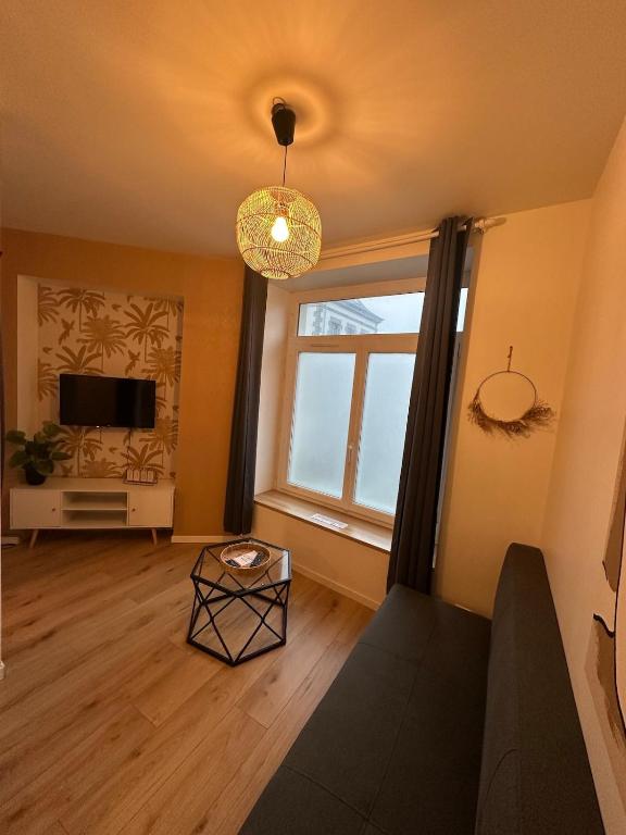 a living room with a couch and a large window at Petit refuge in Saint-Brieuc