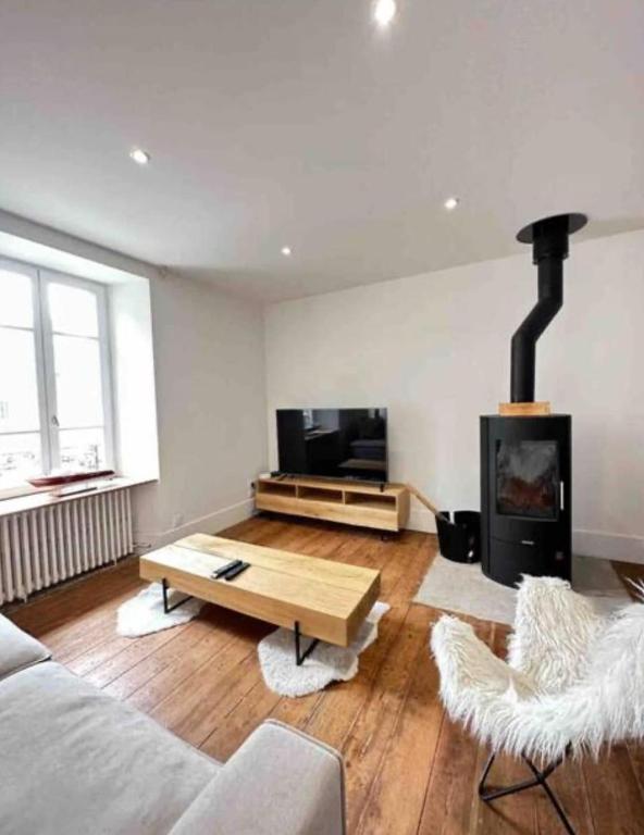 un salon avec un canapé et une cheminée dans l'établissement Au doux repos, à Saint-Quay-Portrieux