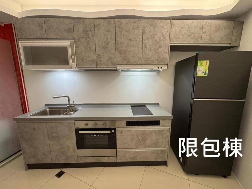 a kitchen with a sink and a refrigerator at Kenting Hostel in Kenting
