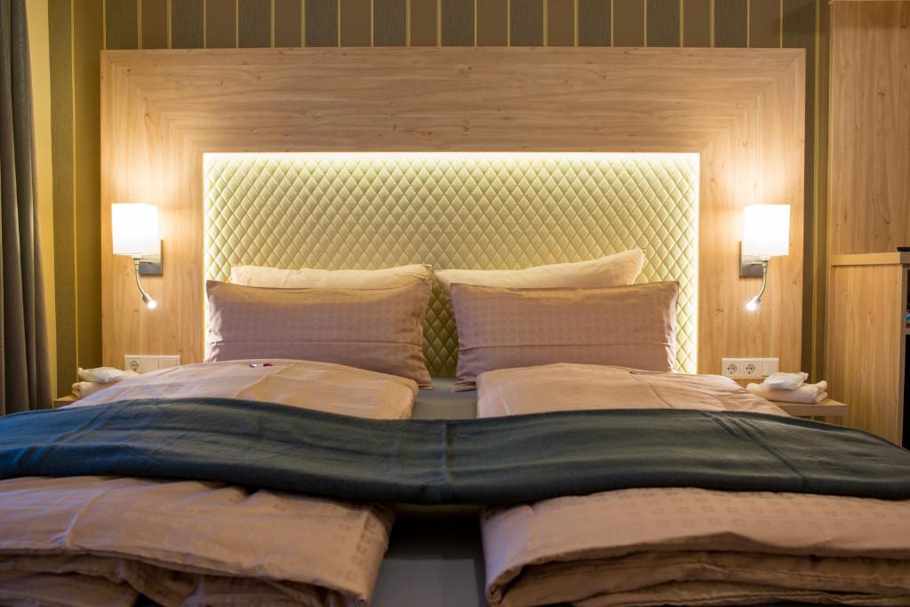 バート・ケーニヒにあるLandhotel Zur Postの大型ベッド1台(2つの照明付)が備わるベッドルーム1室