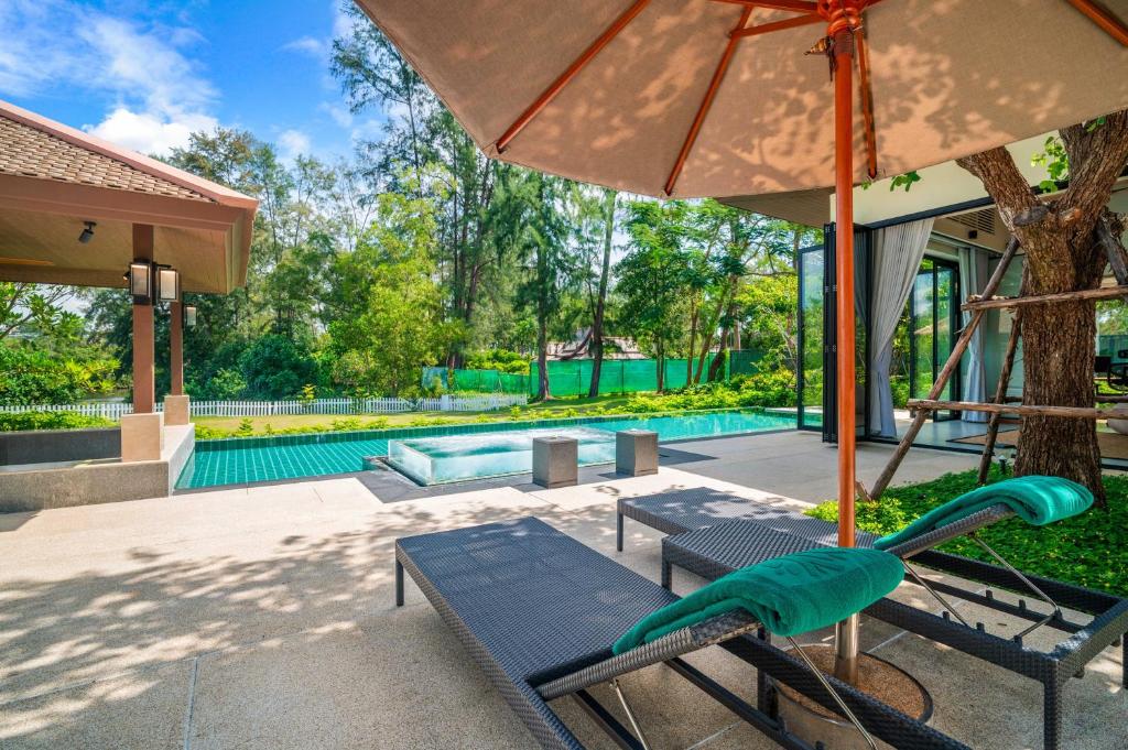 a swing and an umbrella next to a pool at Banyan Tree Grand Residences by Banyan Living in Phuket Town