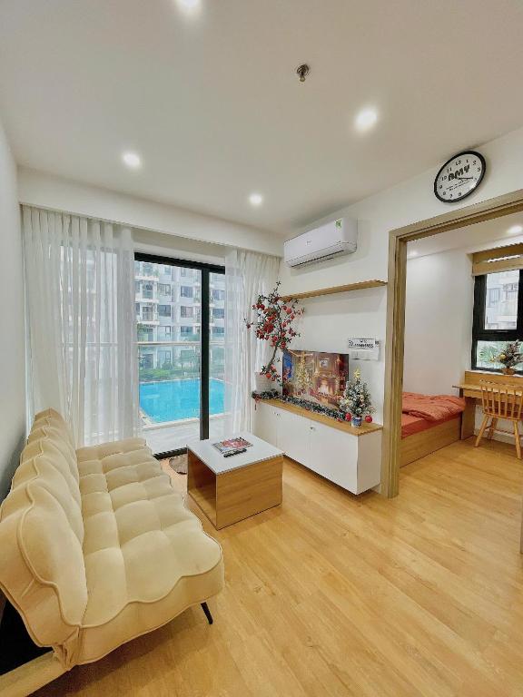 a living room with a couch and a large window at Amy Apartment in Nera Garden Hue in Thôn Văn Dương