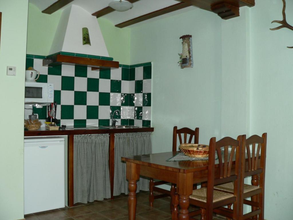 cocina con mesa, sillas y barra en La Insula de Castilnuevo, en Castilnuevo