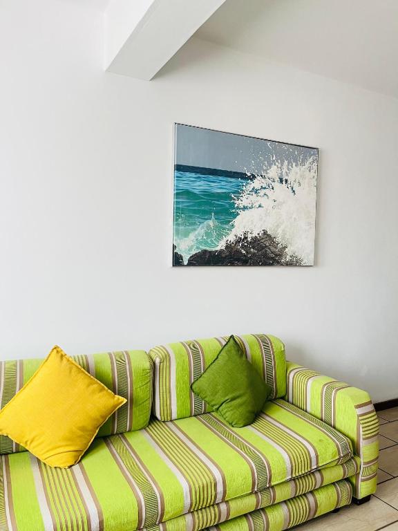 un sofá verde en una habitación con una pintura en la pared en Frere Hill Guesthouse, en Durban