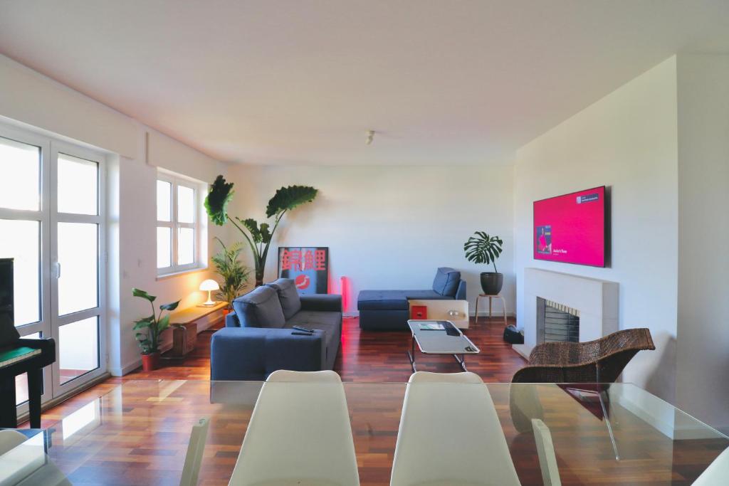 a living room with a couch and a table and chairs at Luxury Condo in Setúbal in Setúbal