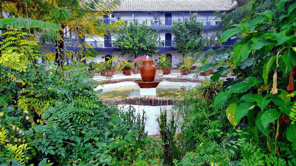 a garden with a large vase in front of a building at Corral del Conde in Seville