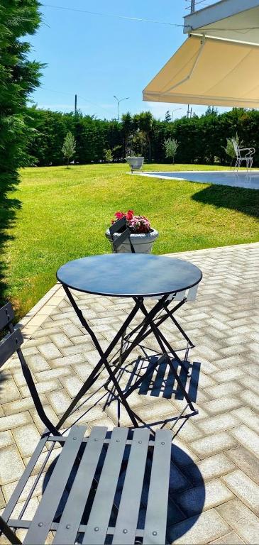 a picnic table and a bench and an umbrella at Cosy Garden Bungalow in Messini