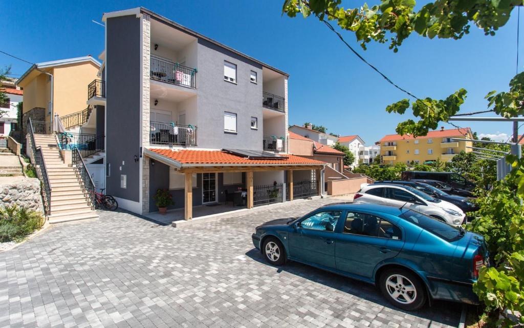 a blue car parked in front of a building at Apartments Bernardeta 1 in Baška